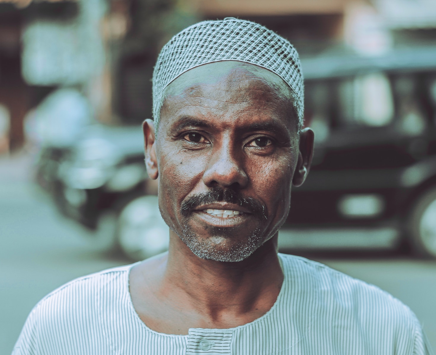 man in white crew neck shirt wearing gray and white checkered bandana